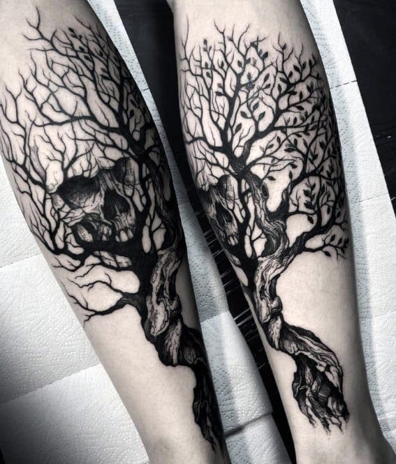 Matching forearm tattoos of twisted trees with branches forming hidden skulls, blending dark surrealism with organic flow.