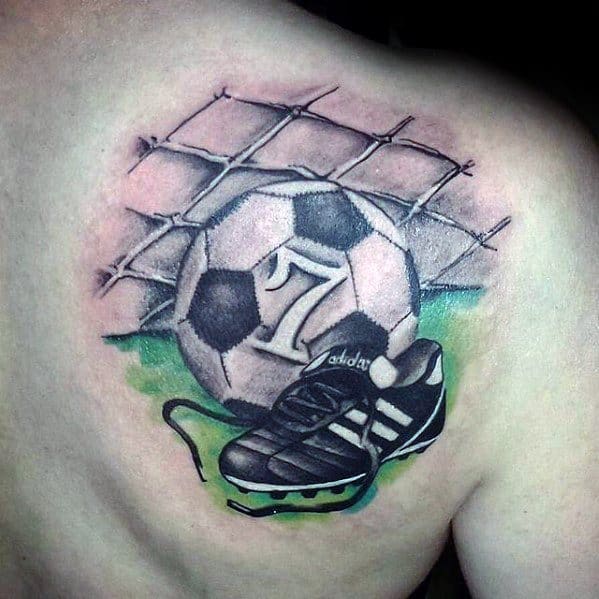 Colorful back tattoo of a soccer ball hitting the net with a cleat in front, symbolizing goal-scoring passion and love for the game.