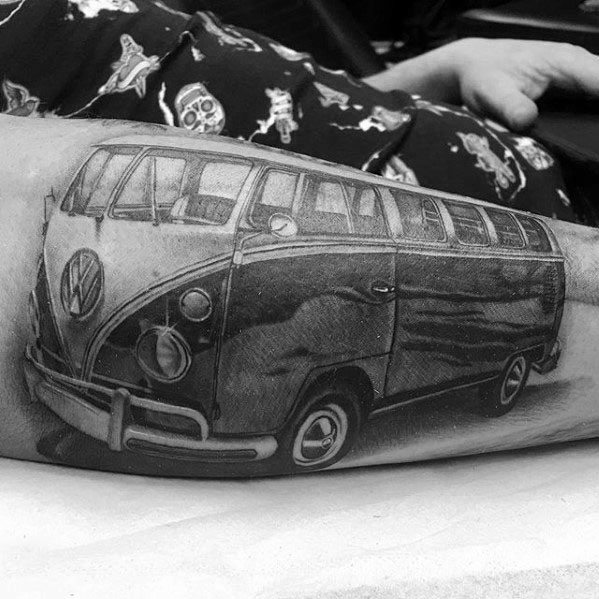 Black and gray tattoo of a detailed vintage Volkswagen van, inked on the forearm with realistic shading and perspective.