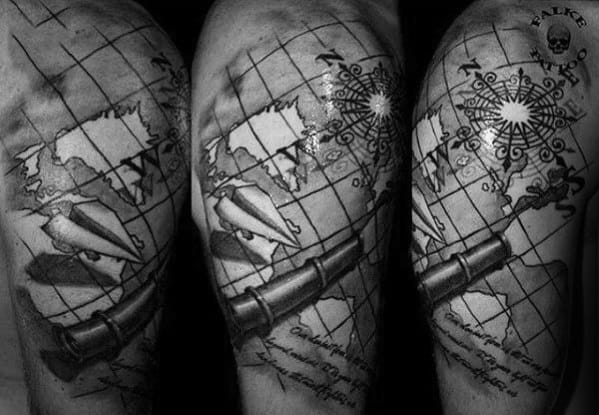 Tattoo of a map, compass, and vintage telescope on an arm