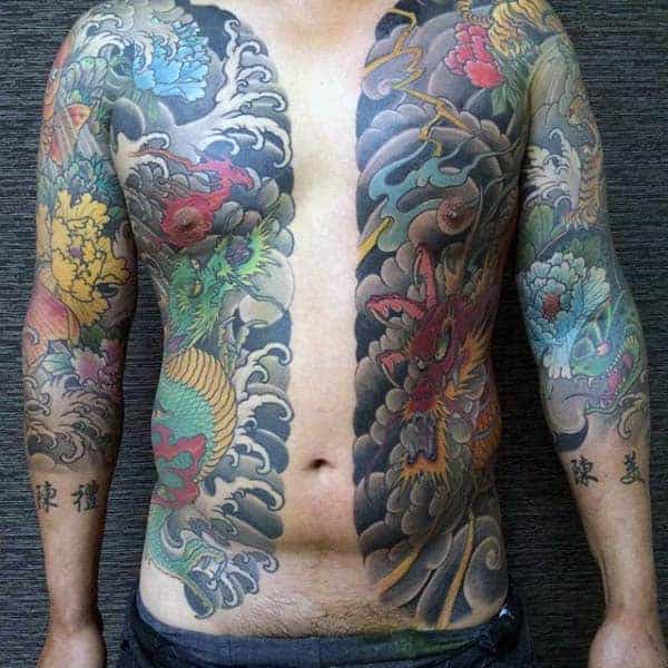Japanese chest and side tattoo featuring vibrant dragons, bold clouds, colorful flowers, and intricate shading on both sides