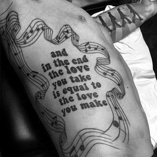Large side tattoo featuring The Beatles' lyric "And in the end the love you take is equal to the love you make" surrounded by flowing musical notes.