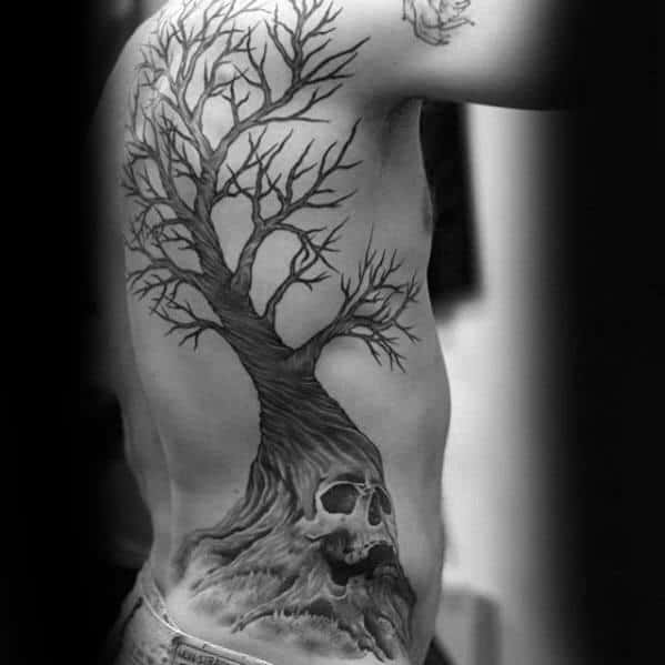 Side torso tattoo of a leafless tree growing from a cracked skull base, symbolizing rebirth and the cycle of life and death.