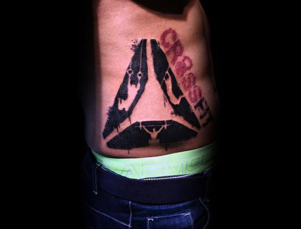 Bold CrossFit tattoo on the side torso featuring a distressed triangular design, pull-up figure, and red stencil-style "CrossFit" text for a rugged look.