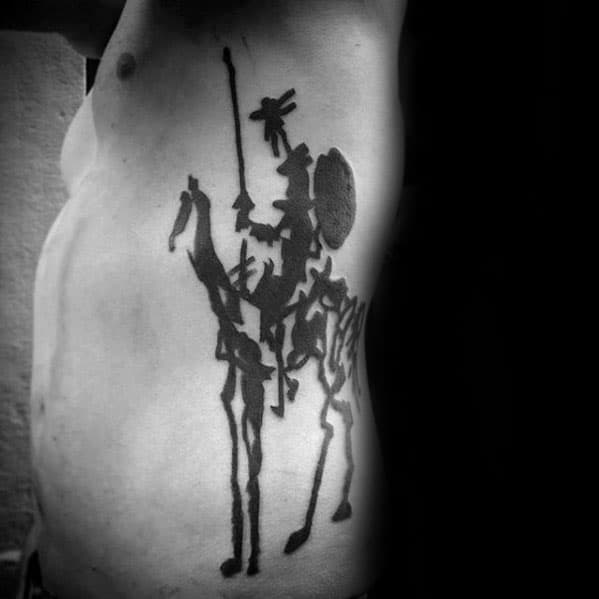 Large ribcage tattoo of Picasso’s *Don Quixote*, with bold black silhouettes of the knight and Sancho Panza in a sketch-like style.