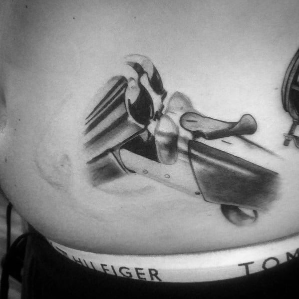 Realistic black and grey tattoo of a double-barrel shotgun in an open position, featuring intricate shading and fine details for a bold design.