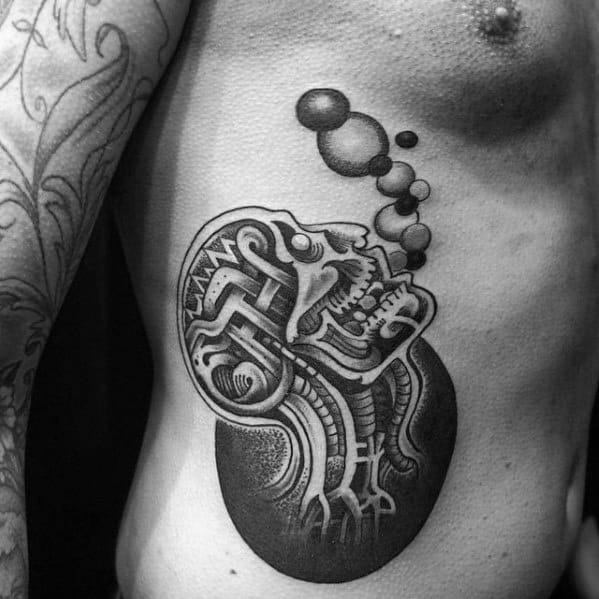 Black and grey tattoo of a skull with abstract, geometric designs, releasing bubbles from its mouth, creating a surreal and thought-provoking composition.