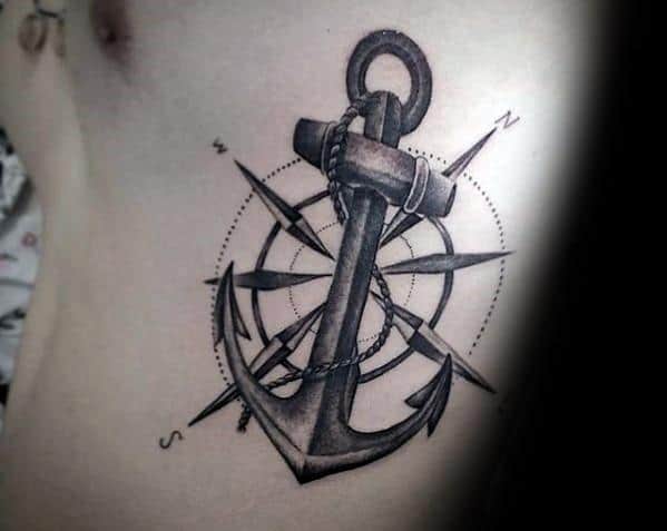 Compass tattoo with intricate anchor and rope in the center on a person's torso