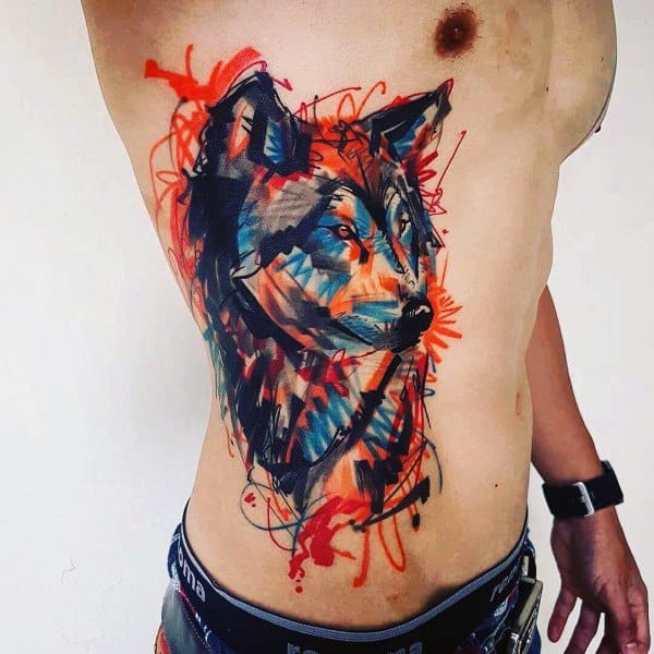 Abstract Siberian Husky tattoo on a man's torso, featuring bold brush strokes, vibrant red and blue splashes, and a dynamic artistic style.