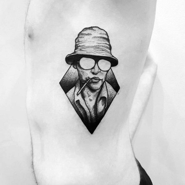 Minimalist black and white Hunter S. Thompson tattoo featuring a geometric design with a stippled portrait, aviator glasses, a bucket hat, and a cigarette.