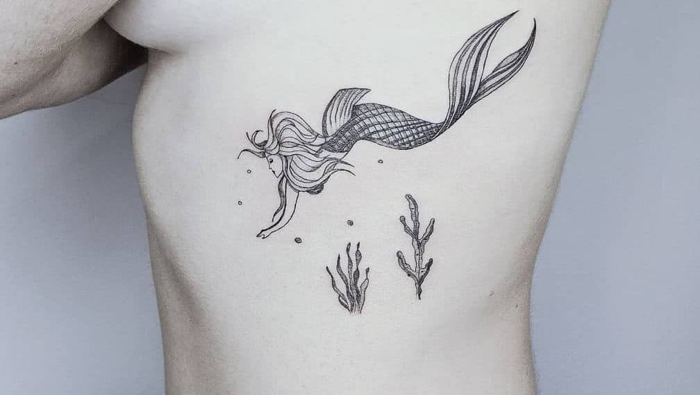 A siren outline tattoo featuring sea plants on a side