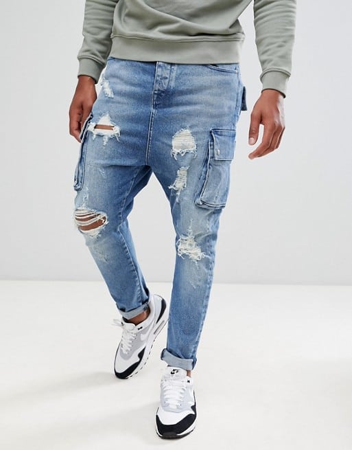 drop crotch jeans in mid wash blue with cargo pockets and rips