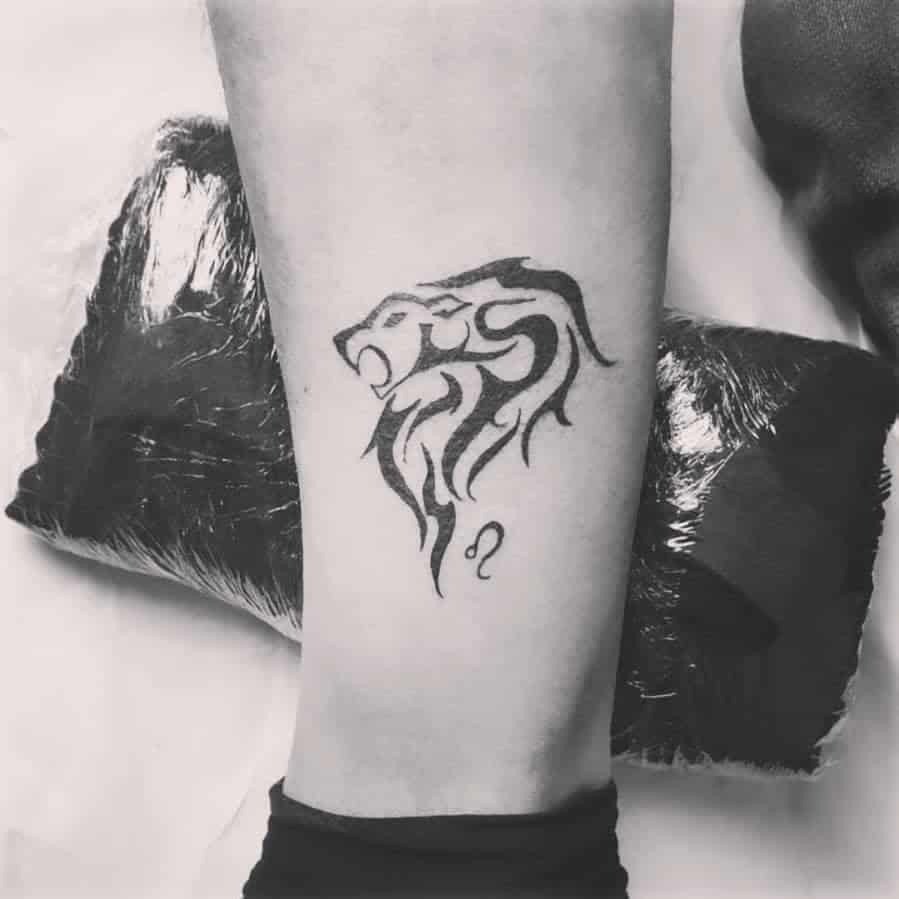 Black ink Leo zodiac tattoo with an abstract tribal lion design, symbolizing strength and courage.