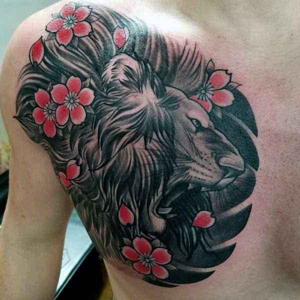 Bold chest tattoo featuring a detailed black and grey lion’s head intertwined with vibrant pink cherry blossoms for a fierce yet elegant look
