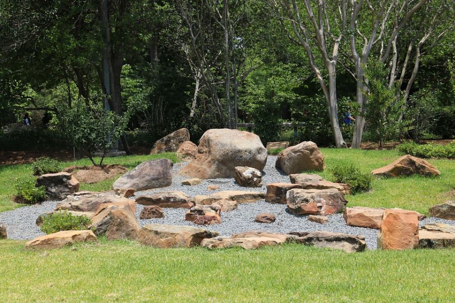 backyard rock garden with gravel path surrounded by grass