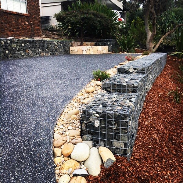 rocks in wire edging backyard driveway pebbles