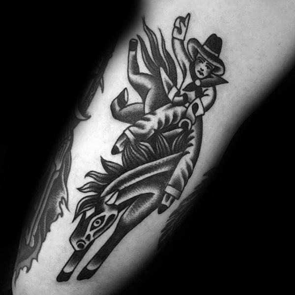 Black and grey traditional-style tattoo of a cowboy riding a bucking horse, featuring bold outlines, dynamic motion, and a classic Western aesthetic.