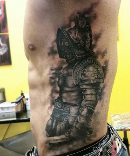 Tattoo of a gladiator's armor on a person's ribcage, featuring detailed shading and realistic features that truly capture the essence of the warrior spirit
