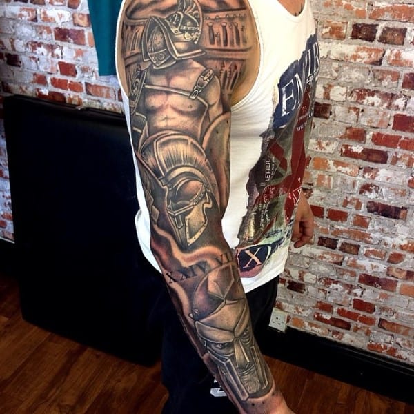 A person with a full sleeve gladiator-themed tattoo on left arm