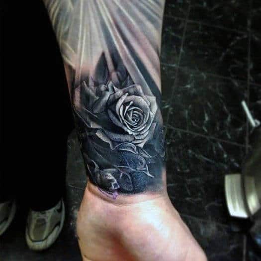 Black and grey rose tattoo on the inner forearm