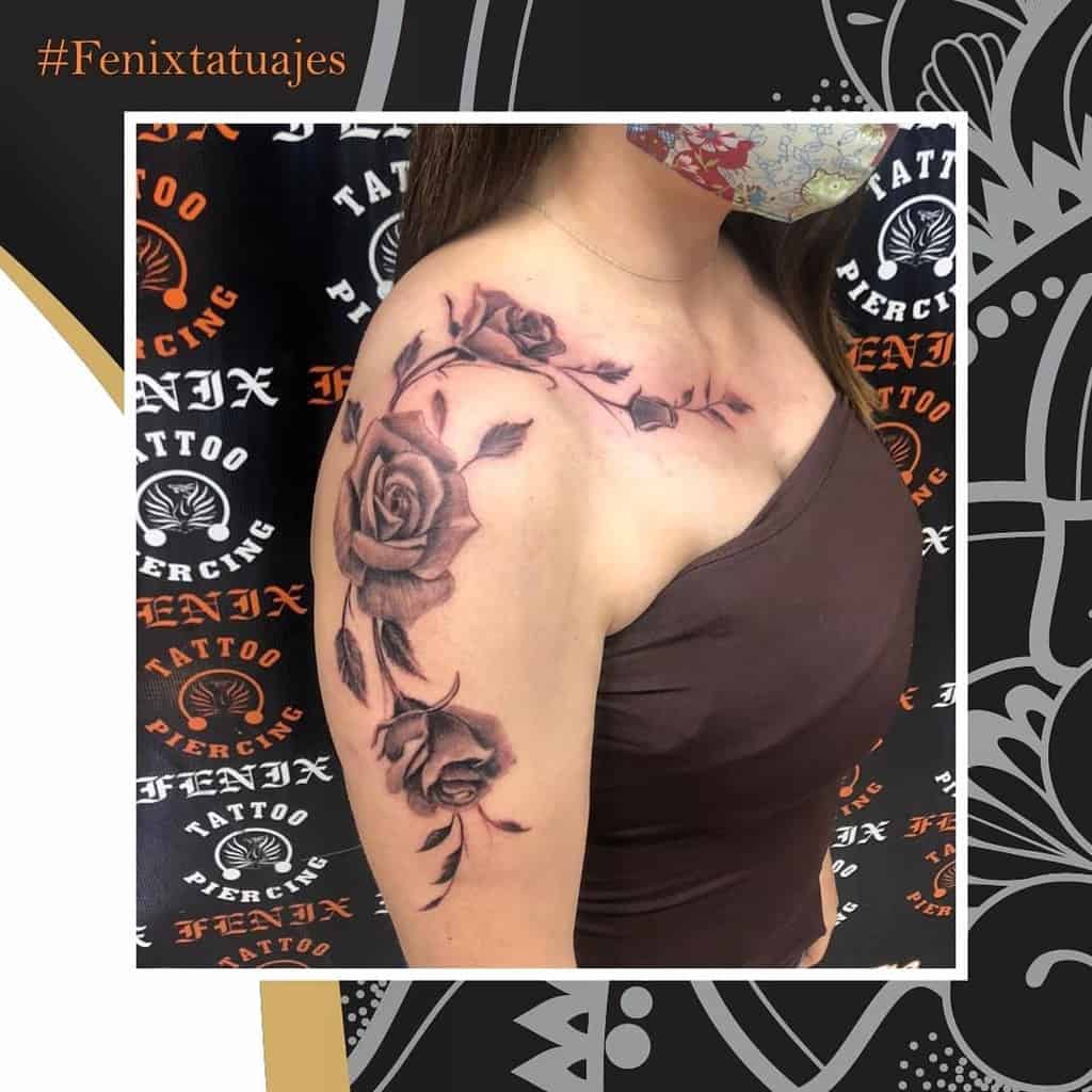 A stunning tattoo of black and gray roses adorning a woman's shoulder and arm