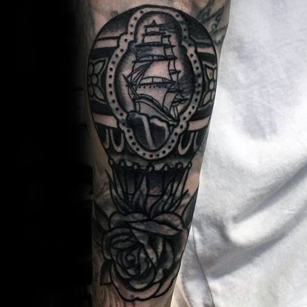 Blast over tattoo of a ship framed with a rose below on an arm