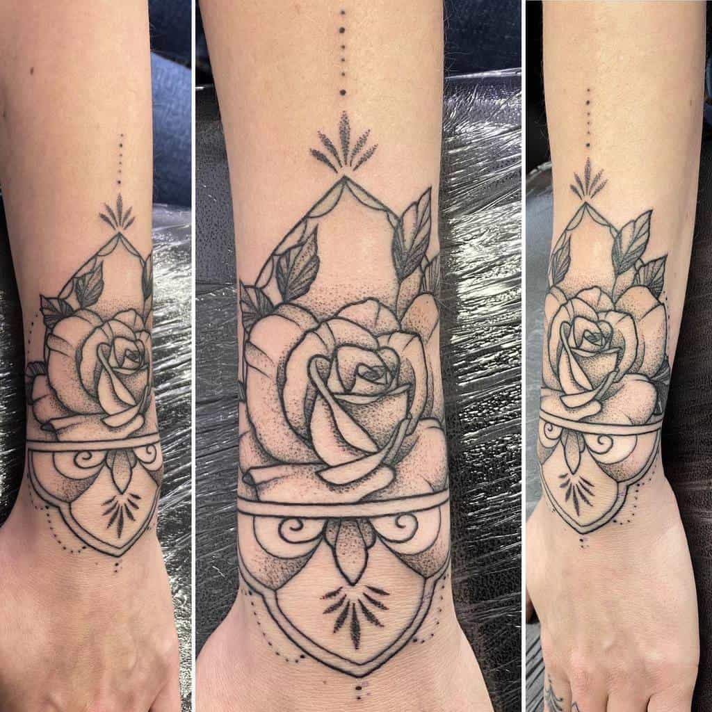 Ornate black and grey rose tattoo on forearm with geometric elements, dot detailing, and intricate designs extending gracefully to the wrist