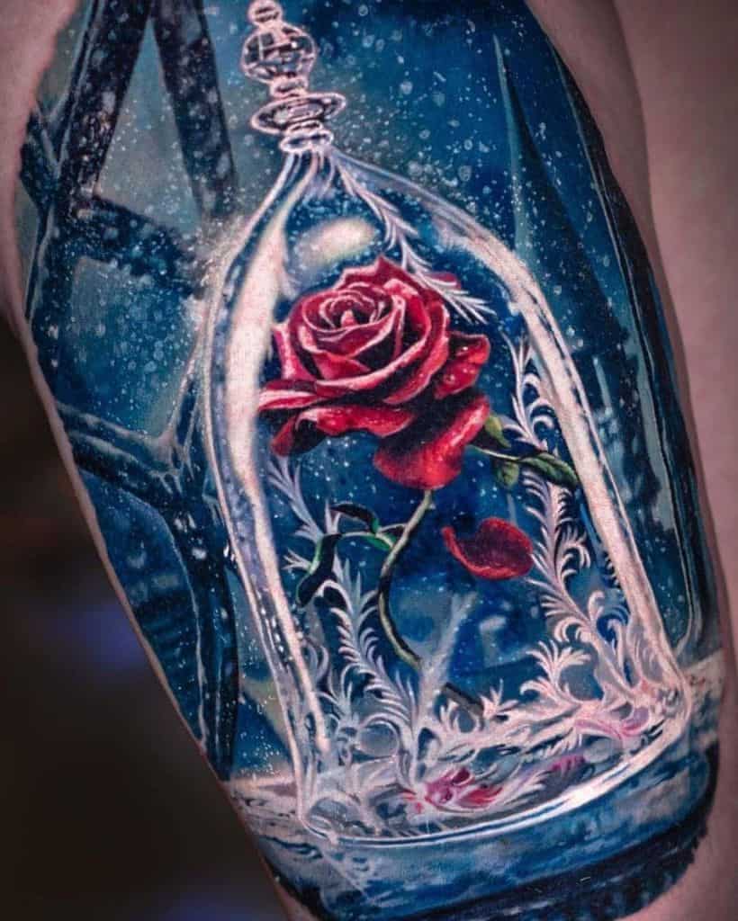 Hyper-realistic tattoo of the enchanted rose inside an ornate glass dome, with intricate details, falling petals, and a snowy blue background.
