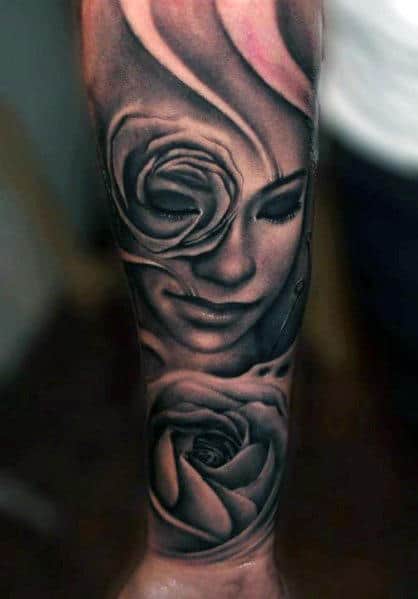 A stunning sleeve tattoo of a woman's face intertwined with roses elegantly covers the forearm