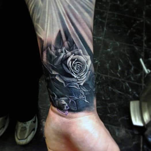 A stunning black and gray rose tattoo adorns the person's wrist, seamlessly flowing into an intricate sleeve with detailed shading and delicate leaves