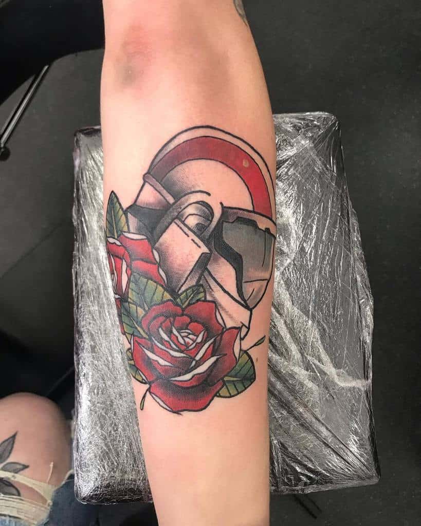 Stylized Halo tattoo of a white and red Spartan helmet, paired with vibrant red roses and green leaves, inked on the forearm.