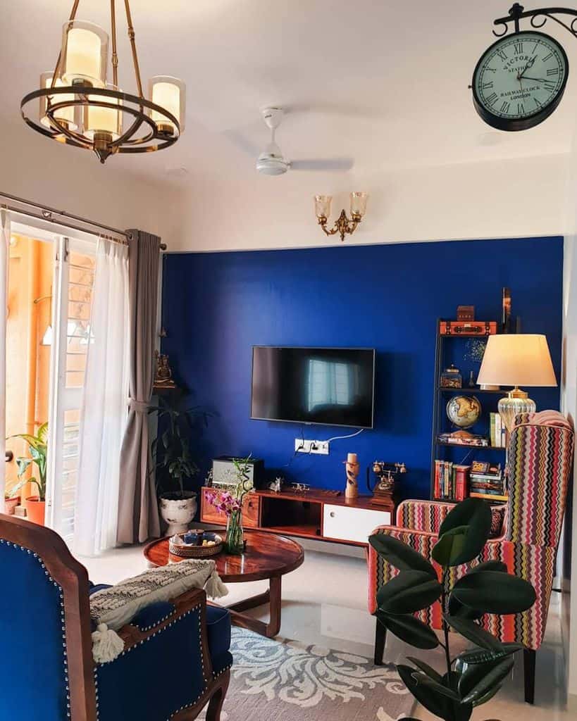 Living room with royal blue accent wall, eclectic furniture, and vibrant decor elements.