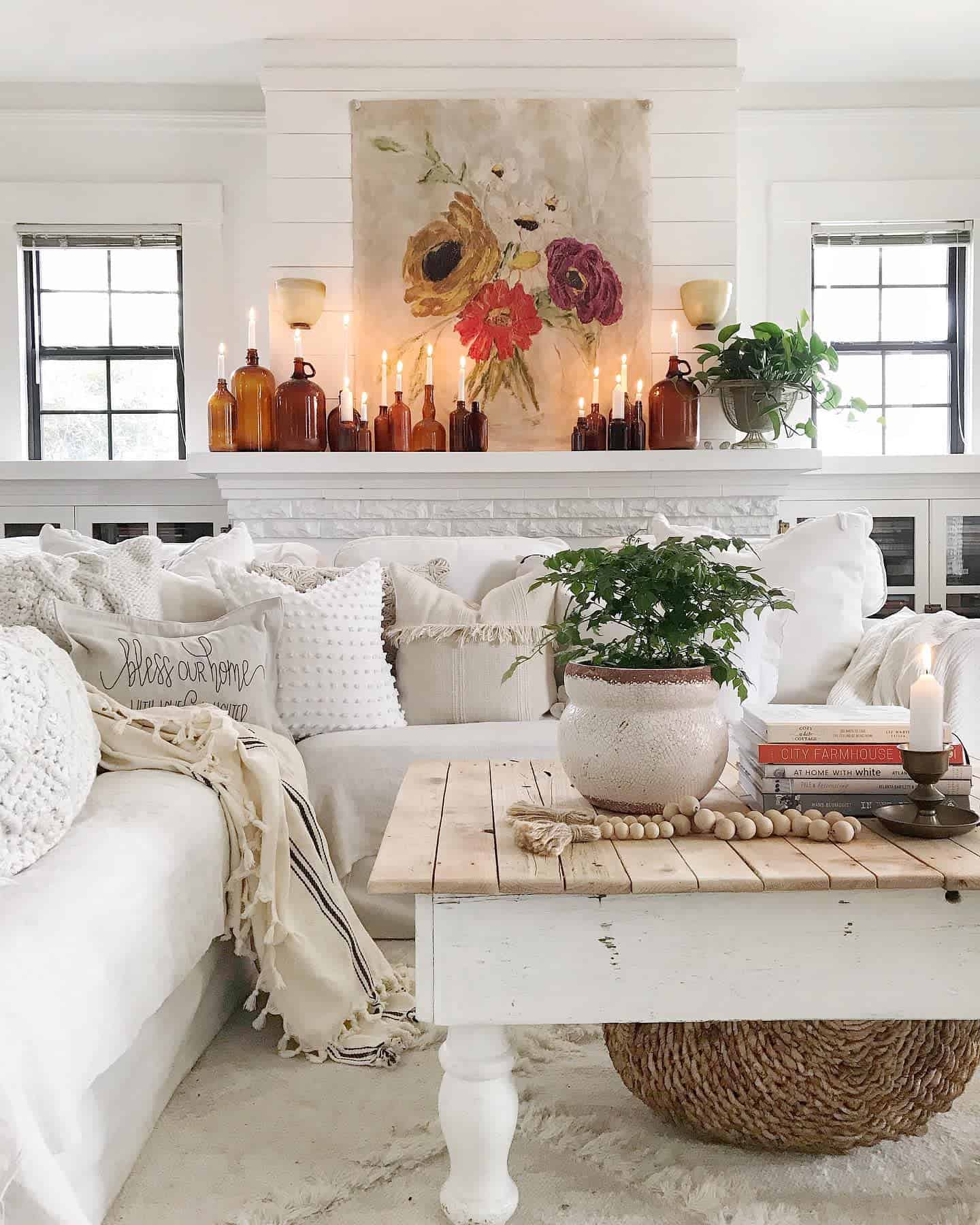 farmhouse living room white sectional sofa candles floral painting 