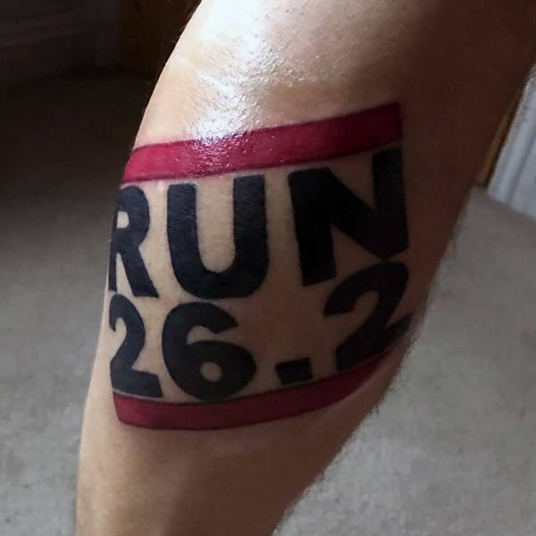 Bold RUN 26.2 tattoo wrapped with red bands, making a strong and stylish statement of marathon pride and accomplishment.