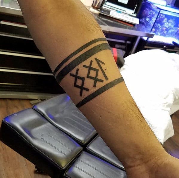 Forearm tattoo with geometric symbols and black bands around the arm