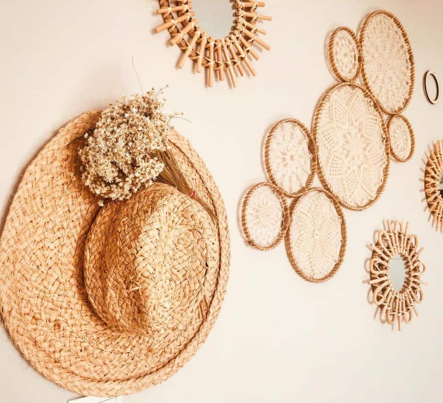 Boho wall decor with woven straw hats, floral accents, and macrame-style circles.