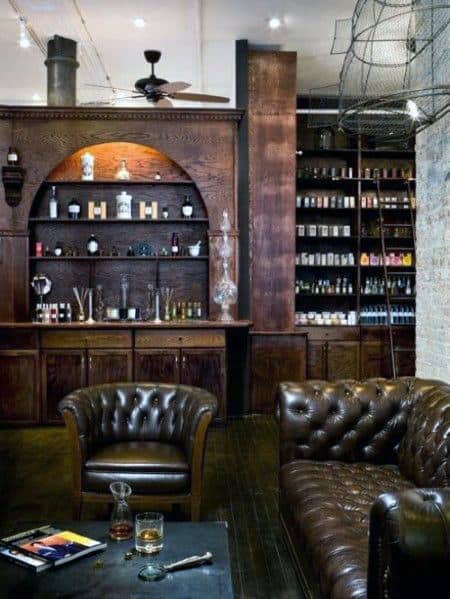 Elegant home bar with dark wood shelves, leather chairs, and stocked liquor display.