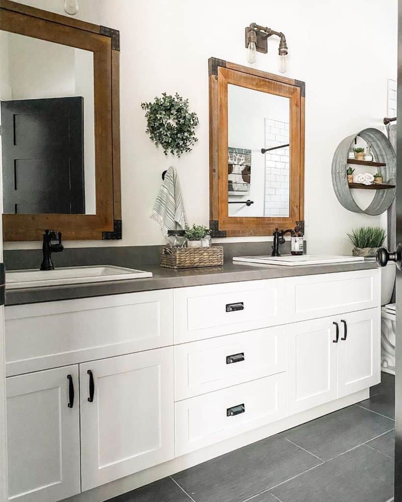 rustic bathroom with white cabinet and dual mirrors