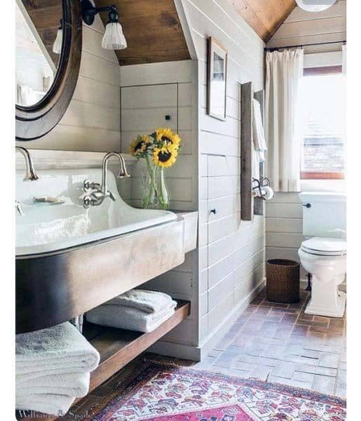 Rustic charm with sunflowers, a round mirror, and white shiplap walls