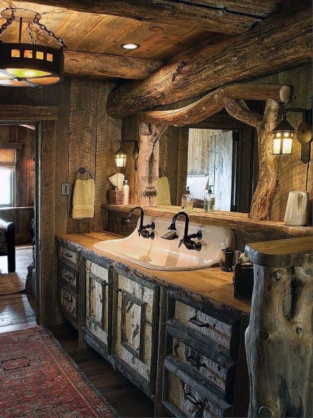 Rustic bathroom with double sink, tree trunk mirror frame, and soft lighting