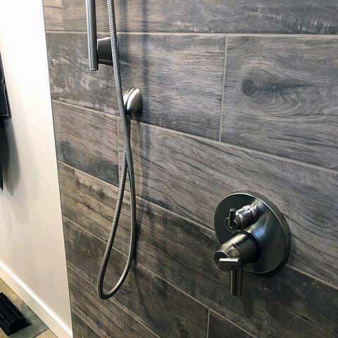 Rustic shower with gray wood-textured tiles and sleek metal fixtures