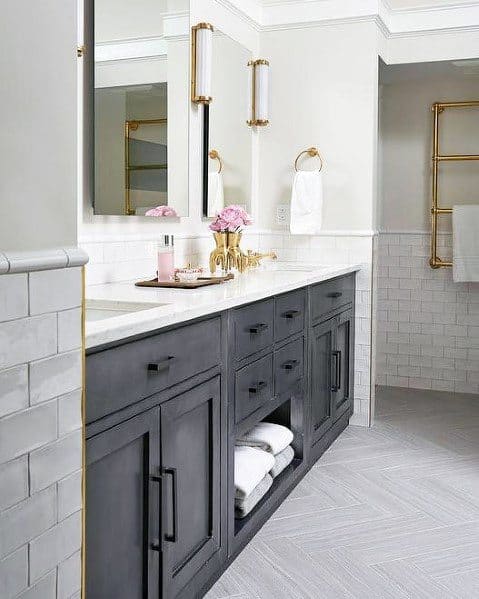 Rustic black vanity with gold fixtures, marble countertop, and open towel storage.