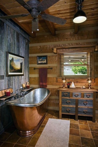 Rustic bathroom with wood beam ceiling, copper bathtub, and reclaimed wood vanity.