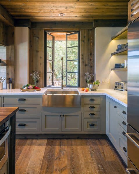 ustic kitchen with farmhouse sink, wooden ceiling, large window, and light gray cabinets.