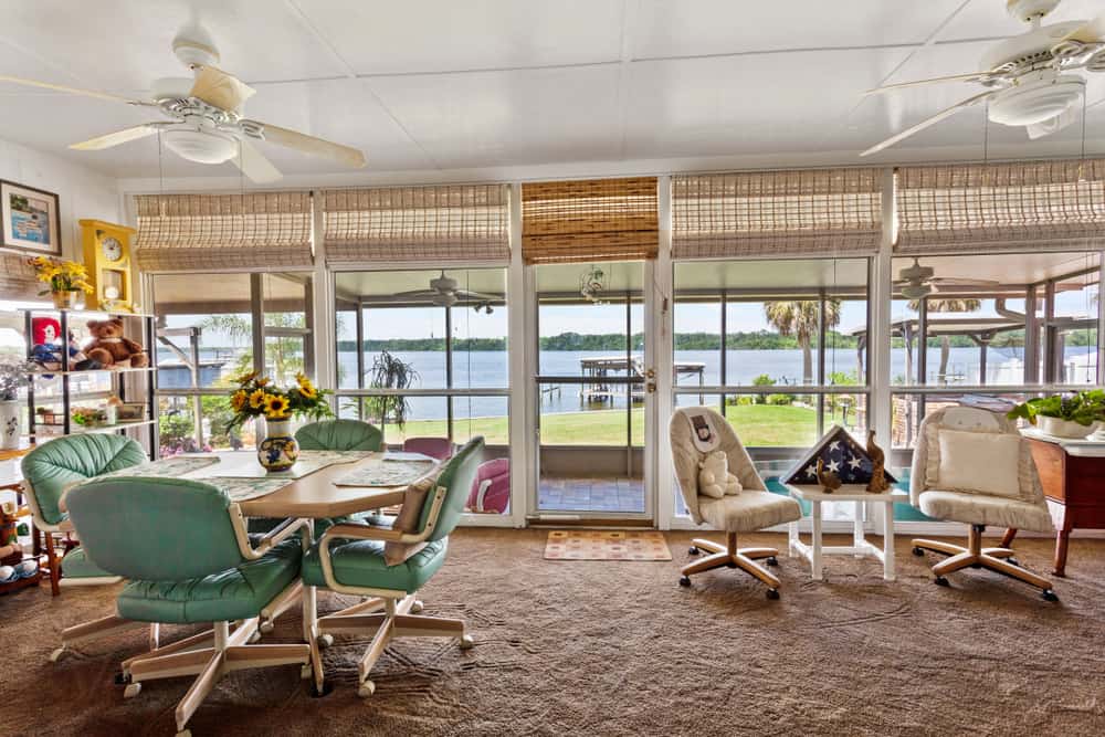 rustic enclosed patio tile floor river view table and chairs ceiling fans