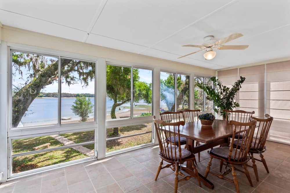 rustic enclosed patio wood dining table and chairs tile floor ceiling fan and light