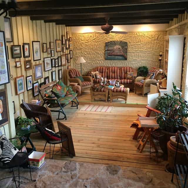 wood deck rustic patio exposed roof beams framed wall art bookshelf wicker furniture 