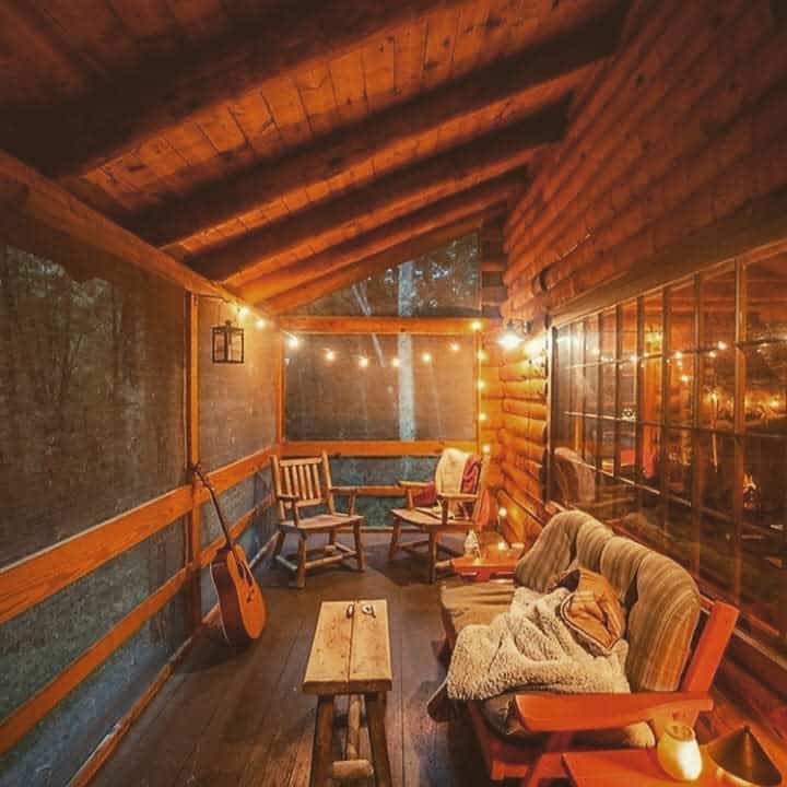 rustic wood enclosed patio fairy lights wood table and chairs guitar 