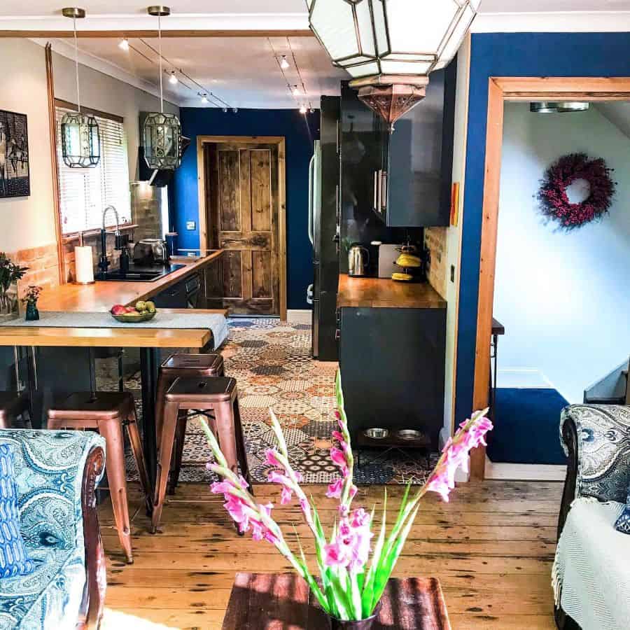 rustic open plan kitchen breakfast bar black cabinets pattern floor rug track lighting