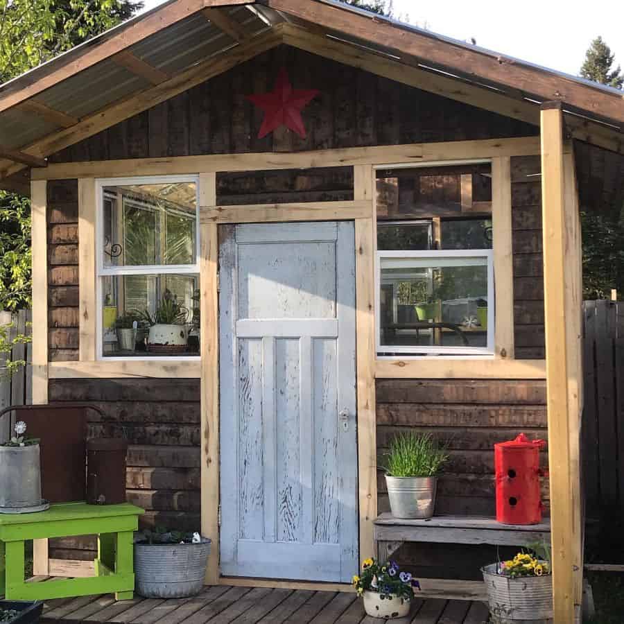 small wood cabin greenhouse white door